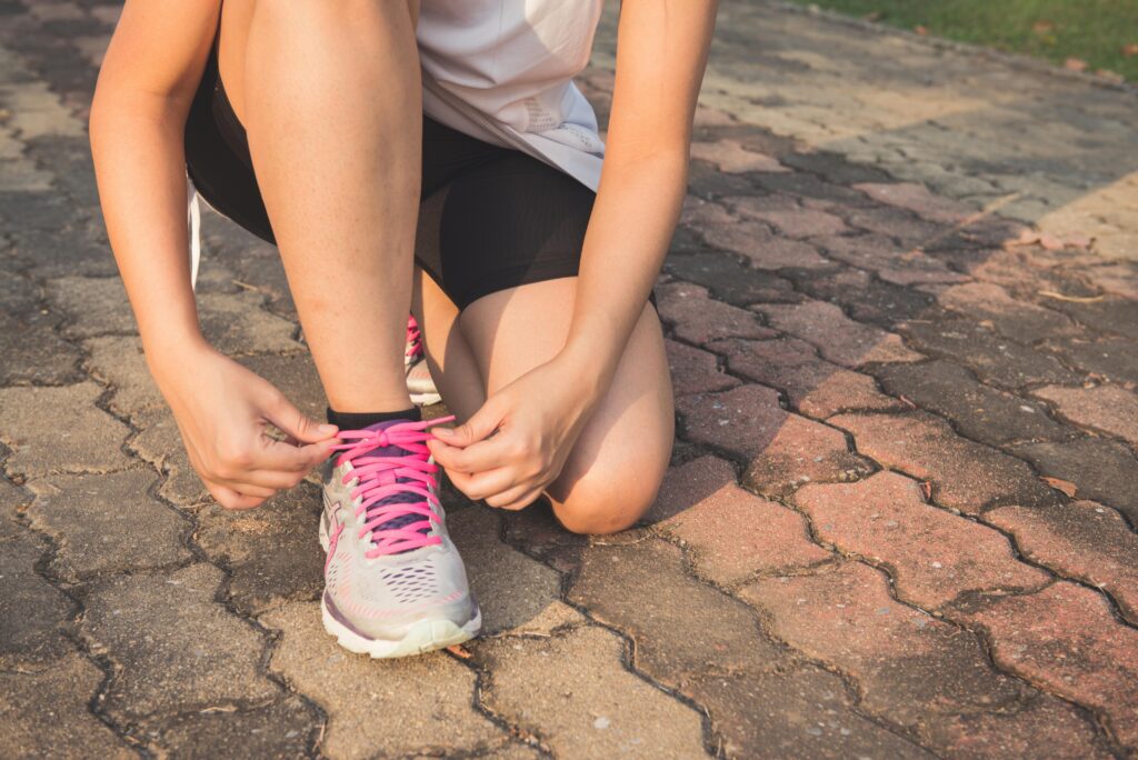 pexels photo 601177 601177 Adult woman tying pink laces on running shoes outdoors. Focuses on fitness and lifestyle.